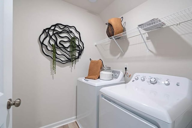 washroom with washer and dryer and wood-type flooring