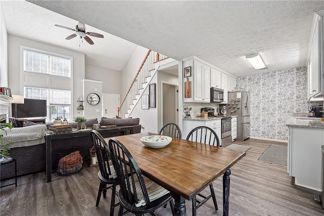 119 Ashley Way, Jefferson, GA 30549 - dining area featuring wood finished floors, wallpapered walls, ceiling fan, stairway, and a textured ceiling