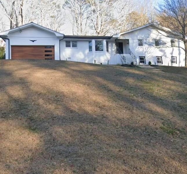 view of front of home with a garage and a front lawn