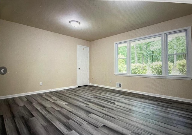 unfurnished room with dark hardwood / wood-style flooring