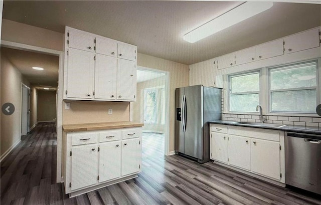 kitchen featuring white cabinetry, appliances with stainless steel finishes, sink, and dark hardwood / wood-style flooring