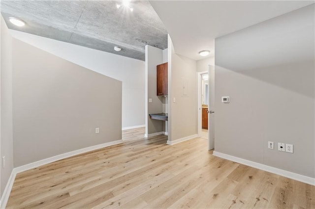 unfurnished room featuring light wood finished floors and baseboards