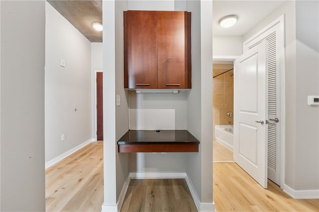hallway featuring light wood-style floors and baseboards
