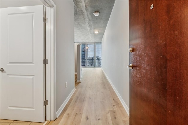 hall featuring light wood-style floors and baseboards
