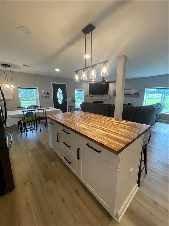 433 Spring Place Reseca Rd, Resaca, GA 30735 - kitchen featuring butcher block counters, light wood-style floors, white cabinetry, open floor plan, and pendant lighting