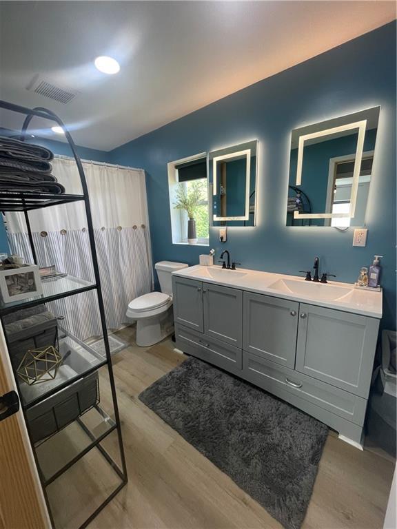 433 Spring Place Reseca Rd, Resaca, GA 30735 - bathroom with double vanity, toilet, wood finished floors, and a shower with curtain