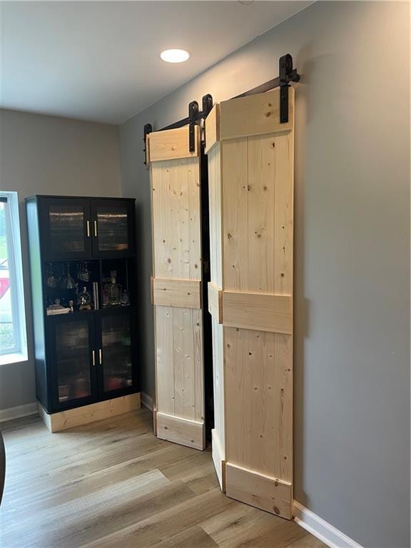 433 Spring Place Reseca Rd, Resaca, GA 30735 - unfurnished bedroom with a barn door, wood finished floors, and baseboards
