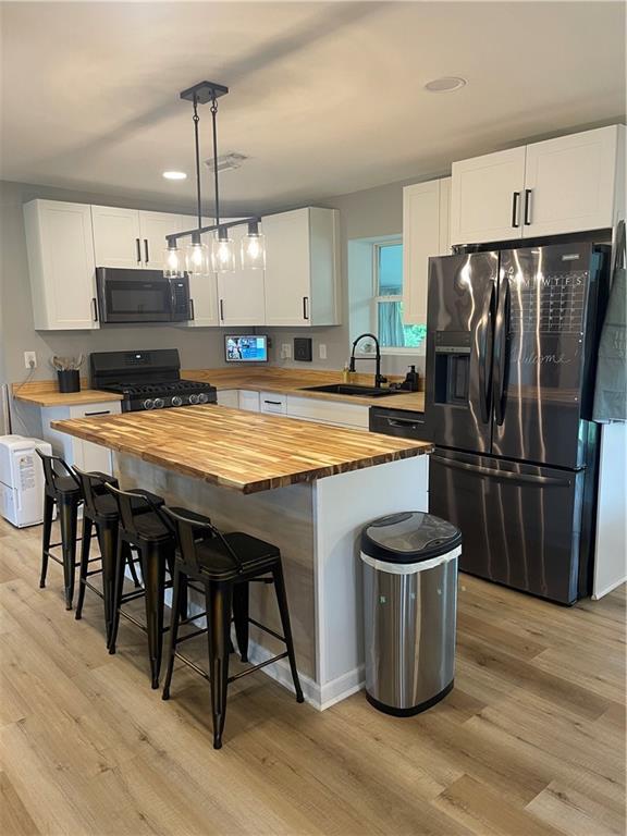 433 Spring Place Reseca Rd, Resaca, GA 30735 - kitchen with wooden counters, black appliances, a sink, light wood finished floors, and recessed lighting