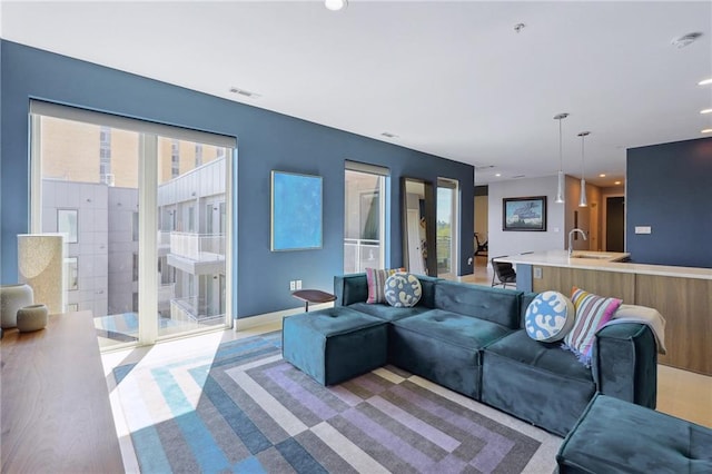 living room featuring sink and light hardwood / wood-style floors