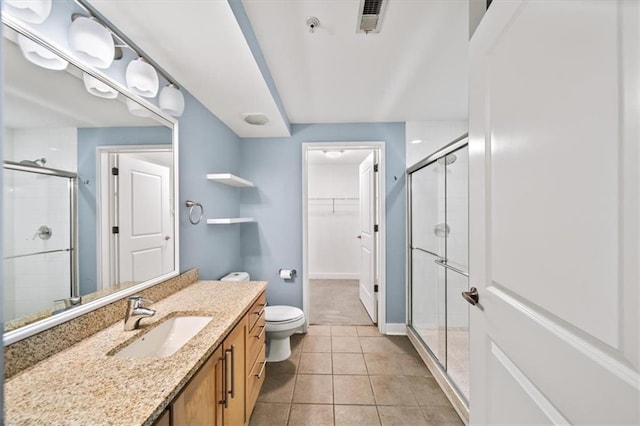 bathroom featuring tile patterned floors, a shower with door, and vanity