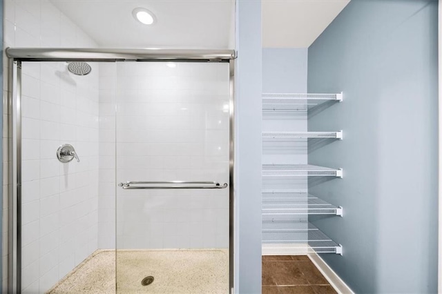 bathroom featuring a shower with shower door and tile patterned flooring