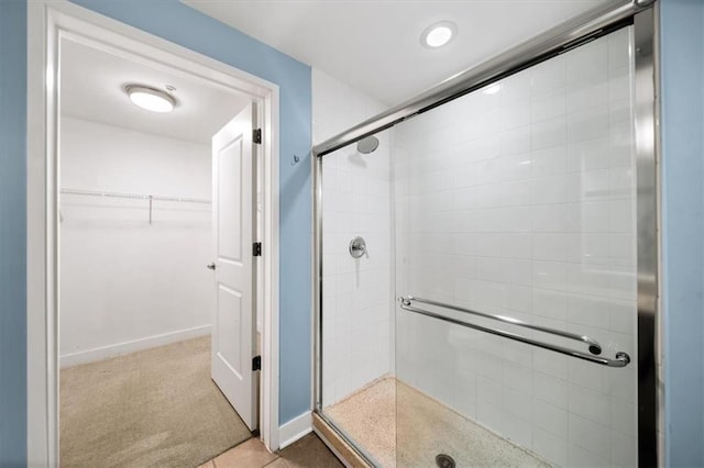 bathroom featuring walk in shower and tile patterned flooring