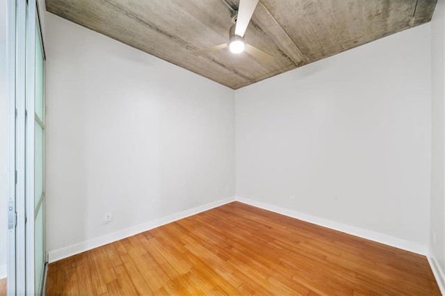 empty room with hardwood / wood-style flooring and ceiling fan