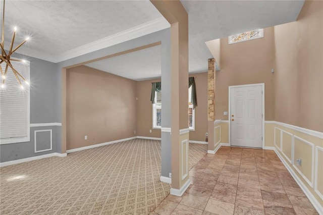 foyer with baseboards and ornamental molding