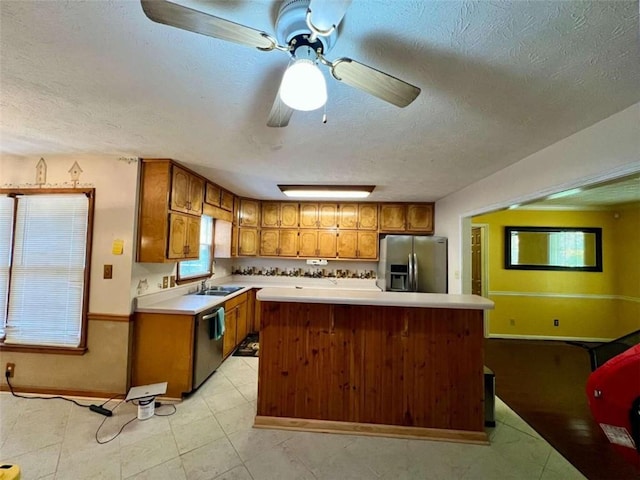 kitchen featuring a kitchen island, sink, a textured ceiling, and stainless steel appliances