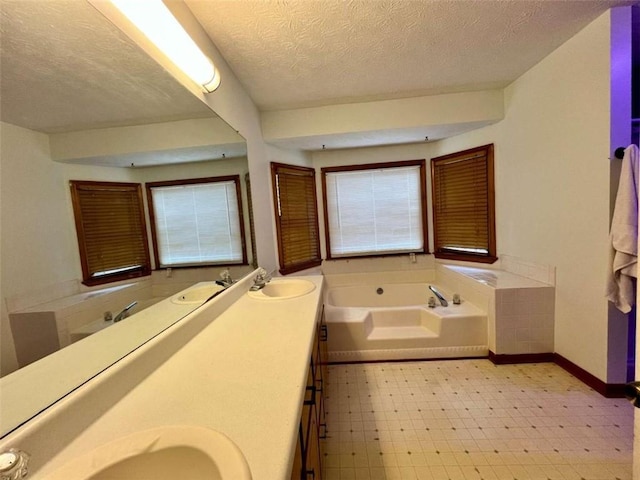 bathroom with vanity, a textured ceiling, and a bathtub