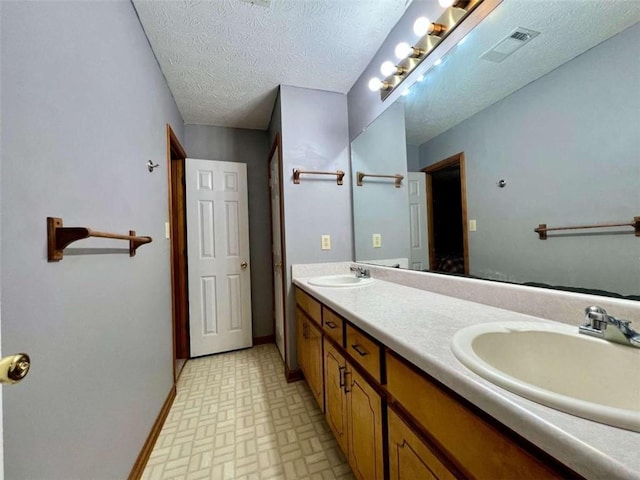 bathroom with vanity and a textured ceiling