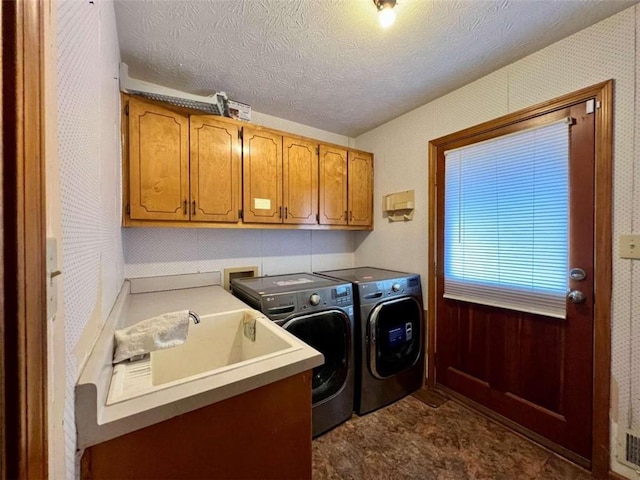 laundry area featuring cabinets, a textured ceiling, and independent washer and dryer