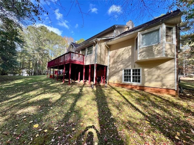 rear view of house with a deck and a lawn