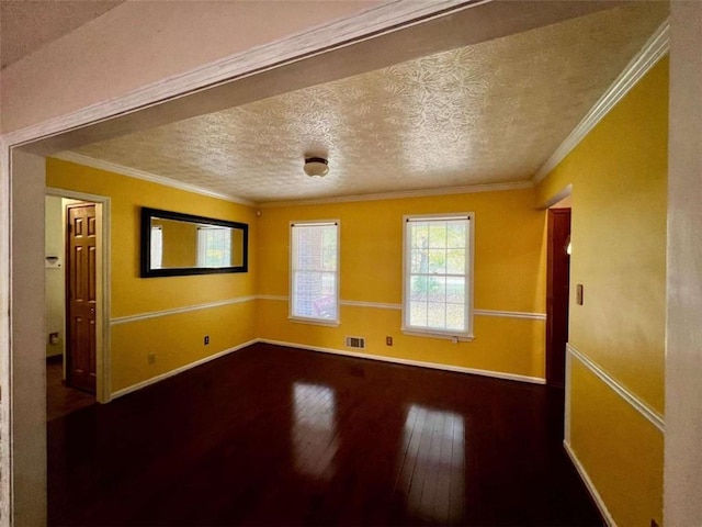 empty room featuring ornamental molding, wood-type flooring, and a textured ceiling