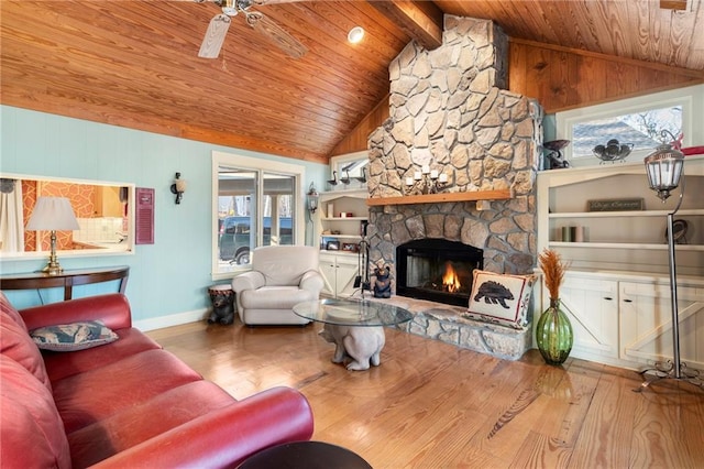 living room featuring plenty of natural light, wood finished floors, and a stone fireplace