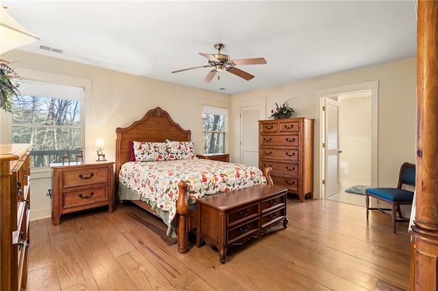 bedroom featuring visible vents, ceiling fan, light wood finished floors, and multiple windows