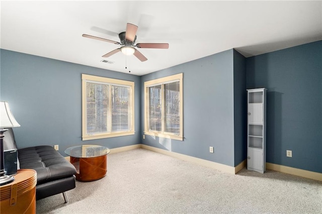 living area featuring carpet floors, ceiling fan, visible vents, and baseboards