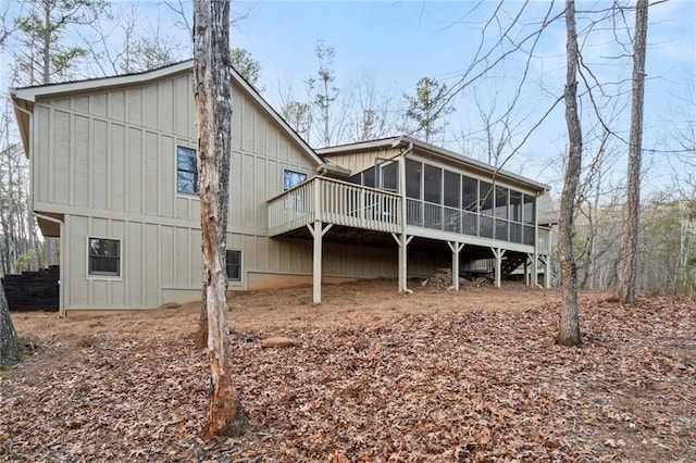 rear view of property with a sunroom and a wooden deck