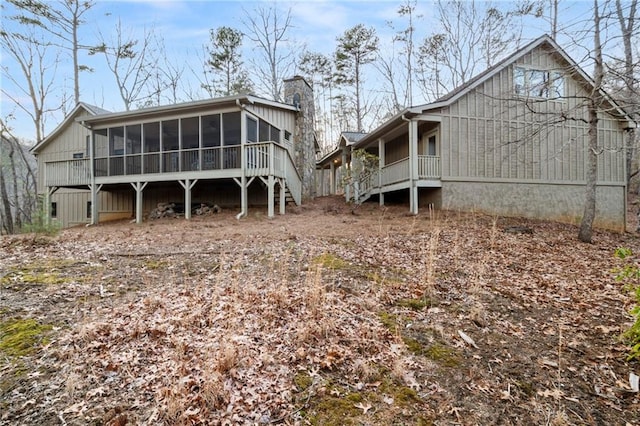 back of property with a sunroom and a chimney