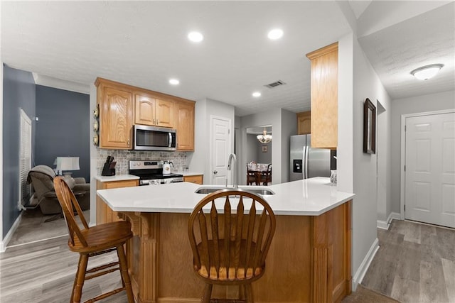 27 Kendall Creek Dr, Jefferson, GA 30549 - kitchen with appliances with stainless steel finishes, light wood-style flooring, light countertops, decorative backsplash, and recessed lighting