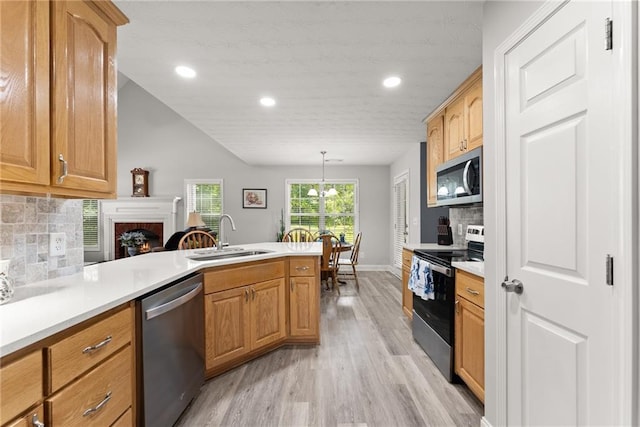 27 Kendall Creek Dr, Jefferson, GA 30549 - kitchen featuring stainless steel appliances, a peninsula, light wood-type flooring, a lit fireplace, and recessed lighting