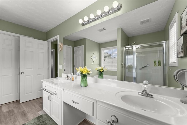 27 Kendall Creek Dr, Jefferson, GA 30549 - bathroom with a shower stall, double vanity, wood finished floors, and a textured ceiling