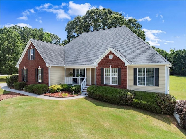 27 Kendall Creek Dr, Jefferson, GA 30549 - view of front facade with brick siding, a front yard, covered porch, and roof with shingles