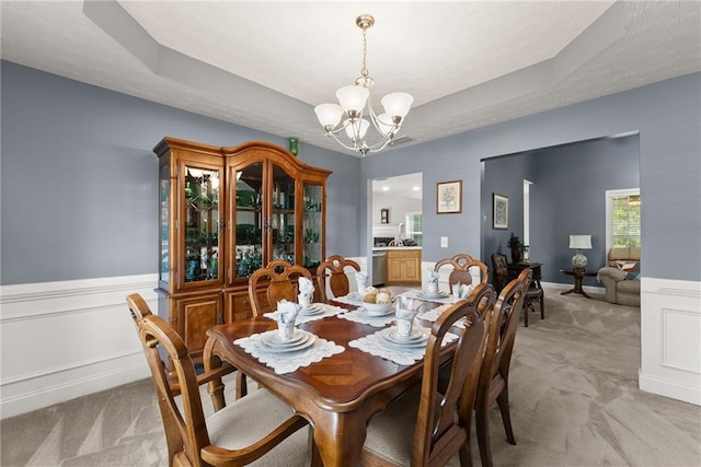 27 Kendall Creek Dr, Jefferson, GA 30549 - dining area featuring light colored carpet, a chandelier, a wainscoted wall, and a tray ceiling