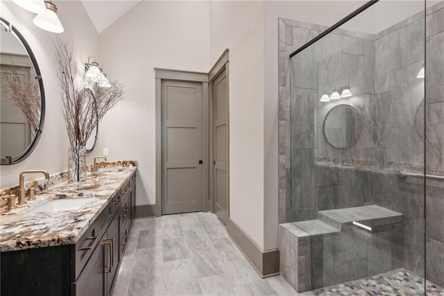 bathroom featuring vanity, lofted ceiling, and a tile shower