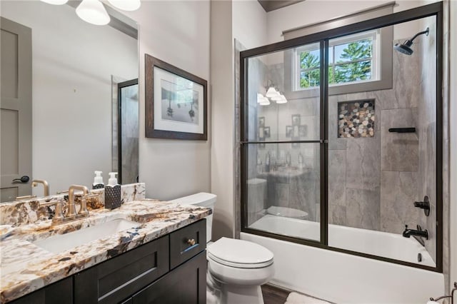 full bathroom with toilet, vanity, and shower / bath combination with glass door