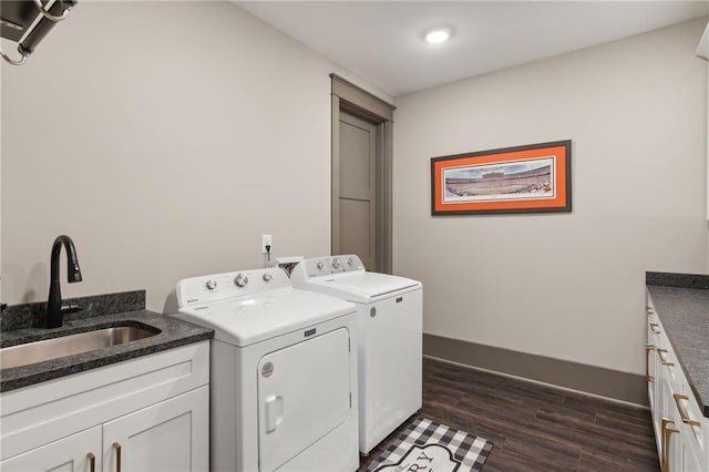 washroom with cabinets, washing machine and clothes dryer, dark hardwood / wood-style floors, and sink