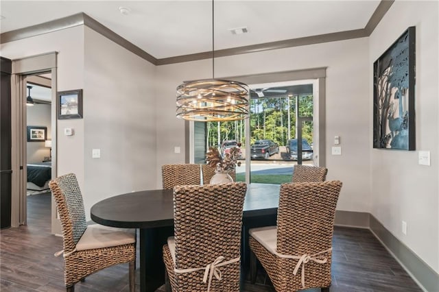 dining room with ornamental molding, dark hardwood / wood-style floors, and ceiling fan with notable chandelier