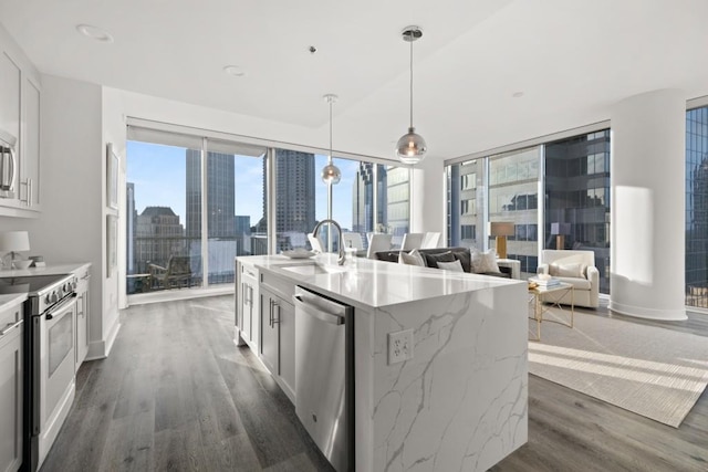 kitchen featuring a sink, stainless steel appliances, a view of city, and a healthy amount of sunlight