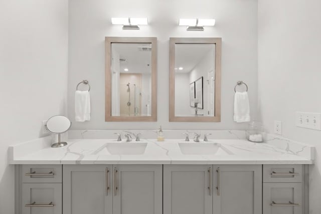 full bathroom with double vanity and a sink