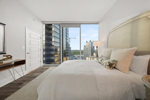 bedroom with wood finished floors, baseboards, and expansive windows