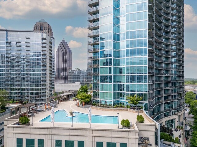 community pool with a patio area and a city view