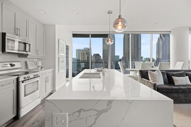 kitchen with a healthy amount of sunlight, appliances with stainless steel finishes, a view of city, and a sink