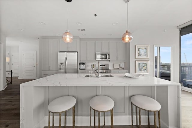 kitchen featuring dark wood-type flooring, visible vents, appliances with stainless steel finishes, and a sink