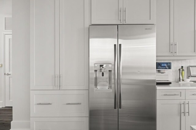 kitchen with light countertops, wood finished floors, and stainless steel fridge