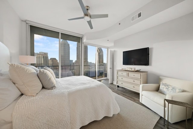 bedroom featuring visible vents, floor to ceiling windows, wood finished floors, a ceiling fan, and access to outside