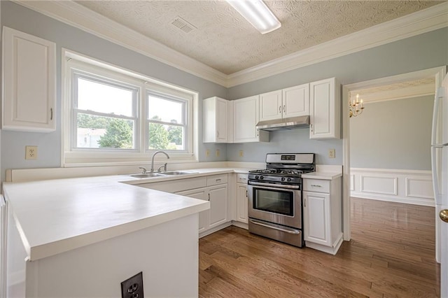 2794 Craig Ct, Marietta, GA 30062 - kitchen with gas stove, under cabinet range hood, white cabinetry, light countertops, and ornamental molding