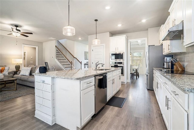 2320 Ridge View Dr, Loganville, GA 30052 - kitchen featuring stainless steel appliances, under cabinet range hood, wood finished floors, open floor plan, and white cabinets