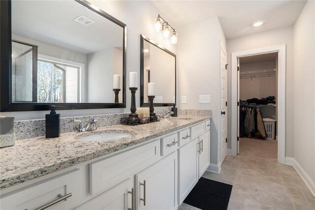 2320 Ridge View Dr, Loganville, GA 30052 - bathroom featuring baseboards, double vanity, and a spacious closet