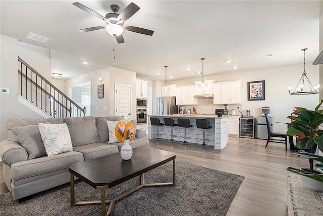 2320 Ridge View Dr, Loganville, GA 30052 - living area with beverage cooler, light wood-style flooring, ceiling fan, recessed lighting, and a chandelier